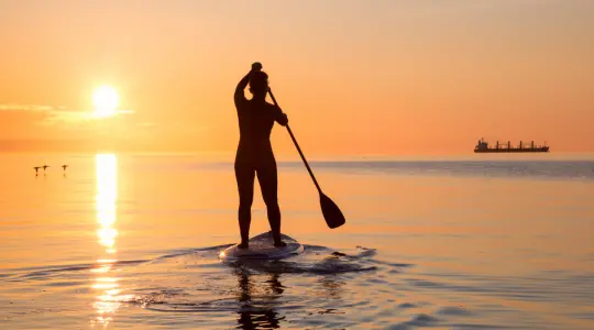 Paddle au coucher du soleil sur la mer
